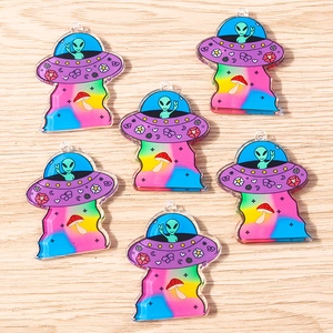 Detailed macro view of 6 colorful acrylic UFO and alien spaceship charms for DIY jewelry making
