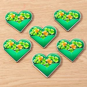 Detail view of heart-shaped St. Patrick's Day pendants with green clover and orange designs