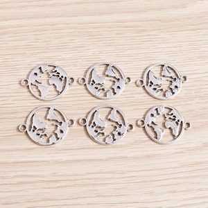 Vue macro de pendentifs mappemonde en argent antique pour création de bijoux DIY