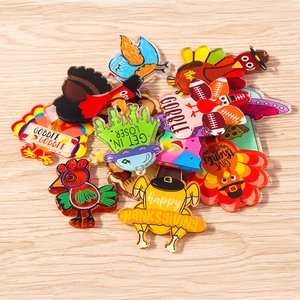 Colorful acrylic Thanksgiving turkey and cartoon pendants on light wood background