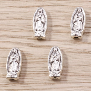 Dettaglio dei ciondoli religiosi della Madonna di Guadalupe in argento antico per gioielli