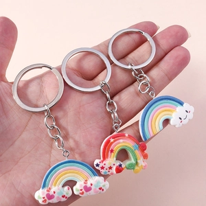 Handheld set of three colorful rainbow and cloud resin keychains with metallic rings