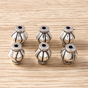 Close-up of vintage silver spindle beads with vertical stripes for DIY jewelry making
