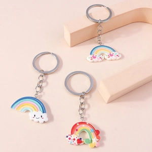 Detailed view of three cute macaron rainbow cloud keychains on geometric pedestals
