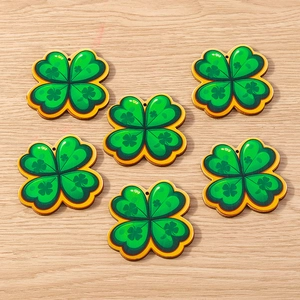 Detailed view of six green wooden clover pendants with yellow edges for DIY craft projects