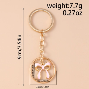 Detailed view of pink bow keychain with dimensions 1.8x2cm and golden keyring specs