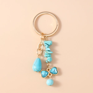 Detailed view of turtle keychain featuring turquoise stones and a blue heart bow charm