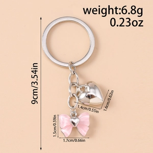 Detail showing dimensions of heart and pink bow keychain on a polished silver ring
