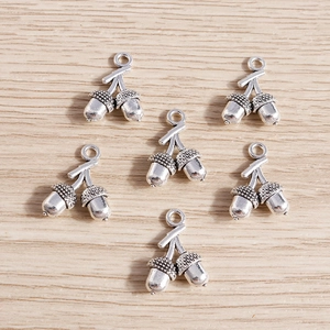 Fünf antike silberne Doppeleichel-Anhänger aus Legierung für DIY-Schmuck auf Holzgrund