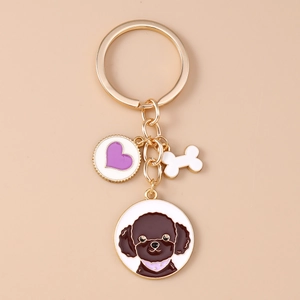 Nahaufnahme von vergoldetem Hunde-Schlüsselanhänger mit Teddy-Motiv, Herz und Knochen