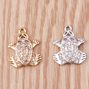 Detail of gold and silver frog charms with inlaid rhinestones and purple zircon eyes