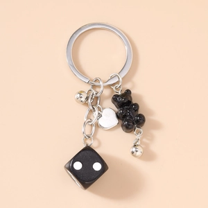 Détail d'un porte-clés tendance avec ours noir, dés et pendentifs en forme de cœur