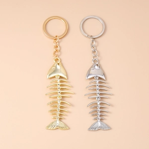 Close-up of creative gold and silver fish bone pendants on metal keychains