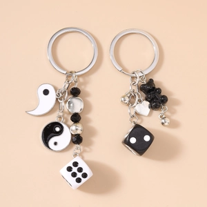 Lot de porte-clés mode avec ours Tai Chi et dés sur un fond beige minimaliste