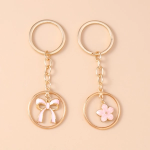 Detail of gold-tone keychains with pink enamel bow and cherry blossom flower charms