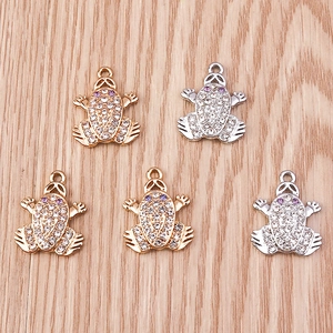 Detailed close-up of gold and silver toad charms with sparkling white and purple rhinestones