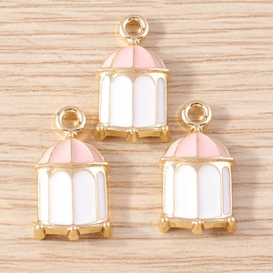 Detail of creative birdcage alloy charms with pink and white enamel in golden finish