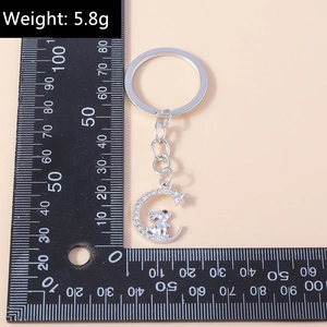 Silver rabbit and moon keychain with sparkling rhinestones measured on a ruler