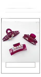 Detail showing red resin hair clips with elegant pearls and sparkling rhinestones