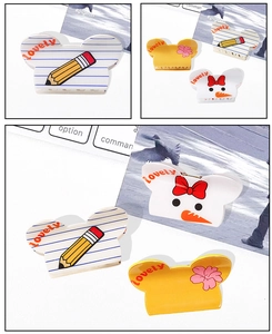 Gros plan de pinces à cheveux cartoon avec texte lovely et motifs colorés sur table blanche