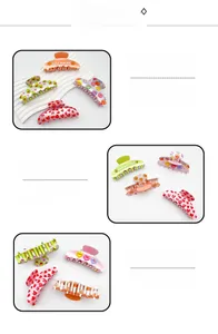Detailed view of colorful acrylic hair claws with peach and avocado patterns