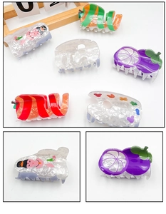 Close-up of acrylic hair claws with fruit shapes and artistic patterns for women