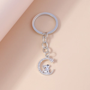 Detailed close-up of a silver crescent moon and rabbit keychain with sparkling rhinestones