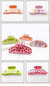 Close-up of vibrant acrylic hair claws with cute fruit prints and colorful patterns
