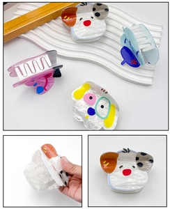 Detailed macro view of cute dog and panda acrylic hair claws with marble texture finish
