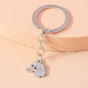 Macro detail of silver elephant keychain with sparkling rhinestones on a pink stand