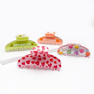 Set of four colorful acrylic hair claws with fruit and heart patterns on white stand