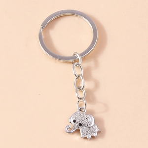 Detailed view of silver elephant keychain with sparkling rhinestones on plain background