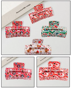 Detailed view of square Christmas hair claws with Santa, reindeer, and gingerbread prints