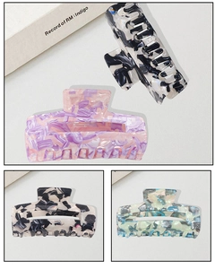Detailed macro view of large acetate hair claw clips with elegant marble patterns