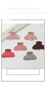 Vue à plat de six pinces à cheveux colorées avec motifs cerises sur fond épuré