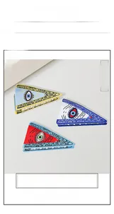 Close-up of three triangle hair claws with colorful eye motifs and wave patterns