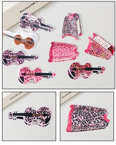 Close-up of violin and vest shaped hair claw clips with pink leopard print patterns