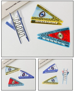 Macro detail of eye pattern PVC hair claw clip showing various color combinations and textures