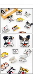 Close-up of cute cartoon dog hair claw clips with marble texture and metal spring detail