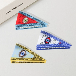 Three triangular Evil Eye hair claws in red, white, and blue colors for women's hair styling