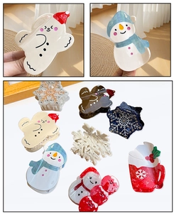 Detailed view of snowman and snowflake acetate hair clips with festive rhinestone accents