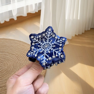 Deep blue snowflake hair claw clip with white patterns and sparkling rhinestones