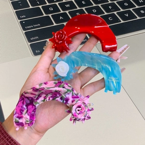 Three-piece acetate hair claw clips with 3D rose decor in red, blue, and floral patterns