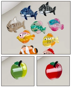 Détail de mini pinces à cheveux en acétate en forme de poissons et de pommes