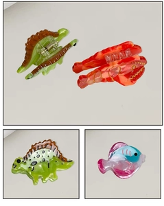 Détail des mini pinces à cheveux en acétate aux formes de homard, dinosaure et poisson
