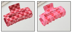 Detailed macro view of heart pattern hair claw clips in pink and red resin finish