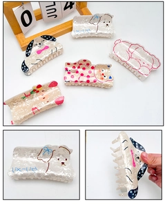 Detail showing various animal-shaped acrylic hair claws with a pearlized acetate finish