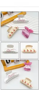 Vue détaillée des pinces à cheveux cerise et des barrettes Baby en strass