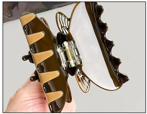 Détail d'une grande pince à cheveux papillon ambre et crème avec ressort doré robuste