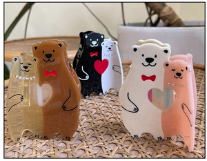 Vue détaillée des pinces à cheveux en acétate en forme d'ours avec nœud et cœur